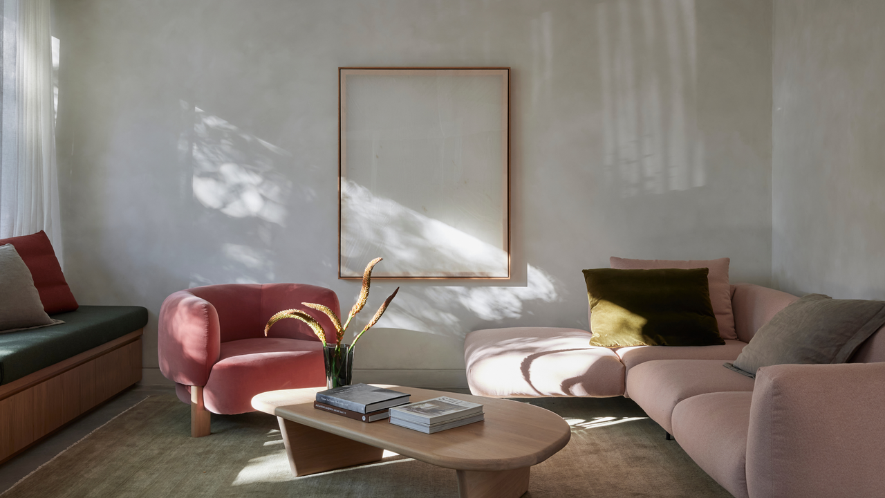 A minimalist limewash living room with a light pink sofa and a dark pink sofa