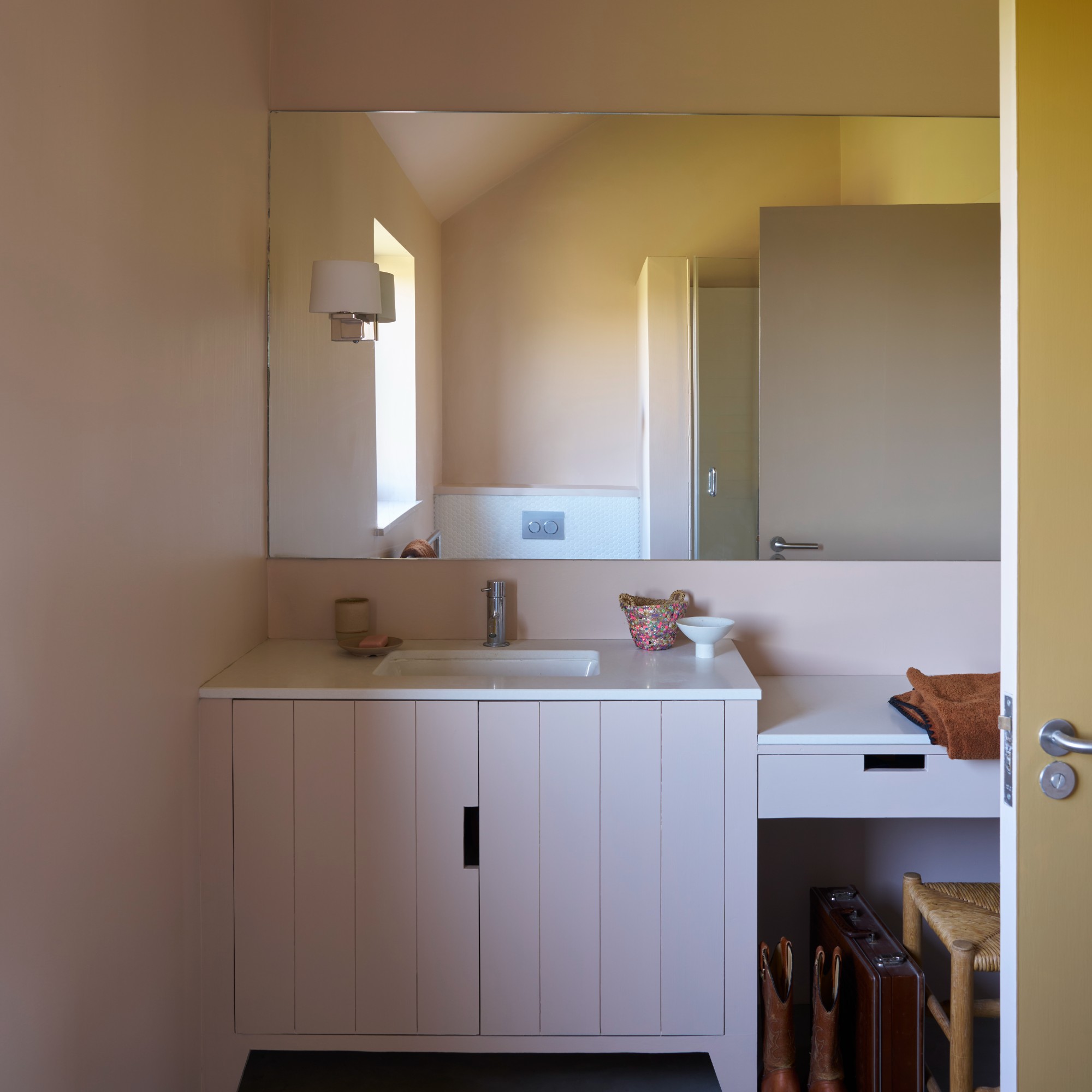 A soft pink bathroom painted in Farrow &amp;amp; Ball&#039;s Scallop shade with a large mirror