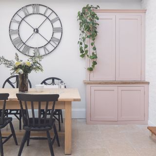 Kitchen with dining table and freestanding pink cabinet