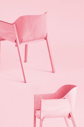 Two pink armchairs photographed against a pink background