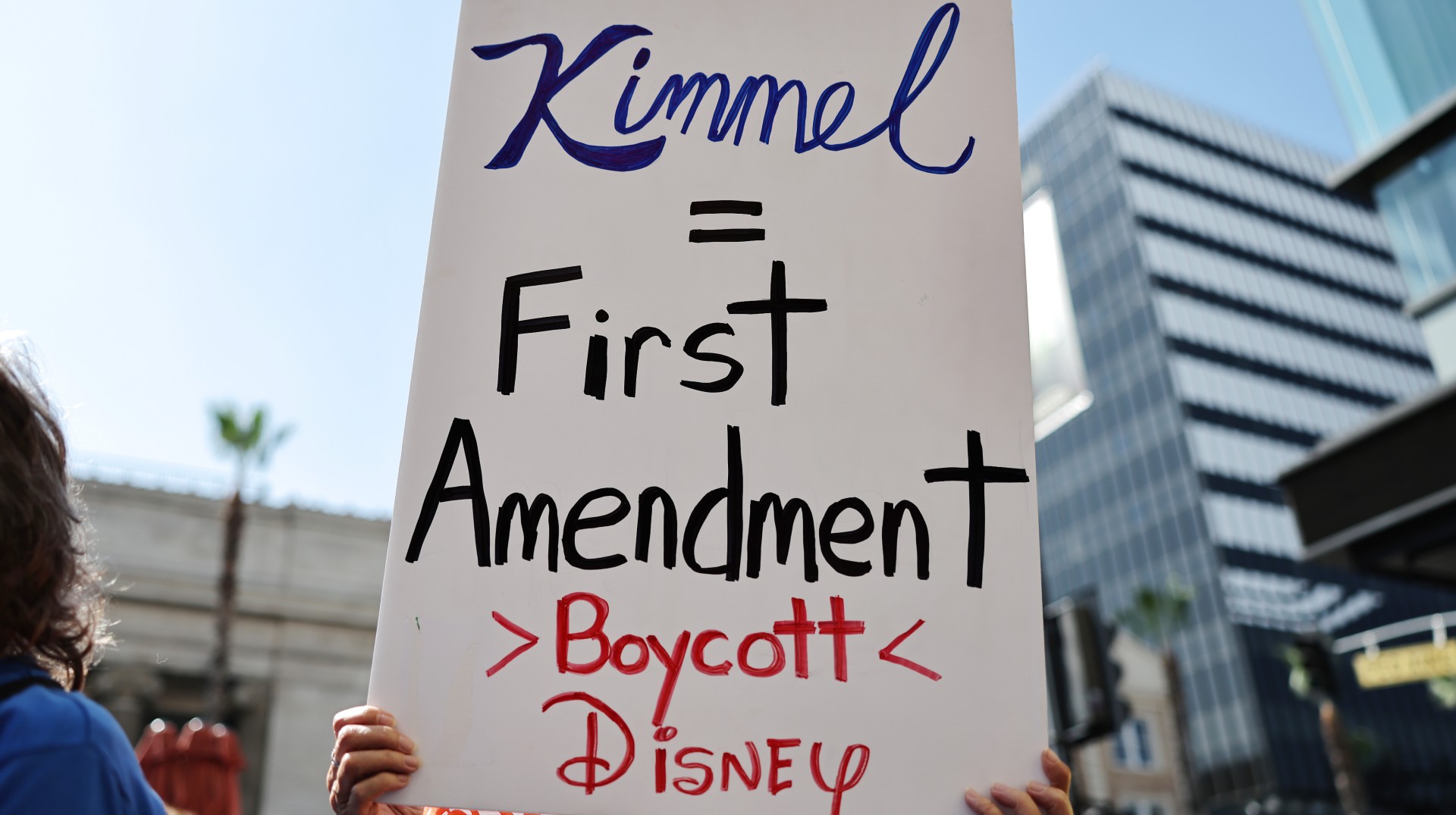 LOS ANGELES, CALIFORNIA - SEPTEMBER 22: A demonstrator holds a sign during a protest against the suspension of the "Jimmy Kimmel Live!" show, held across the street from the theater where the show is produced in Hollywood, on September 22, 2025 in Los Angeles, California. A contingent of Hollywood union members, along with Democratic members of the House of Representatives, participated in the event "to defend Americans' constitutional right to free speech.” Kimmel's ABC late-night show has been "indefinitely" taken off the air following controversy over his comments about the killing of Charlie Kirk. 