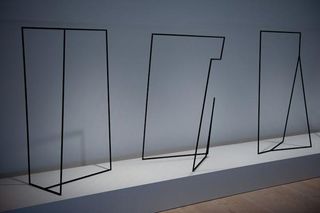 Three black abstract steel frame photographed on a white surface against a white background