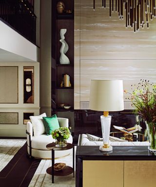 off white living room with cream furniture, brass chandelier and cream table lamp