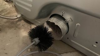 Dryer vent being cleaned by brush