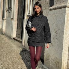 Fashion influencer @salome.mory wearing a chic winter outfit styled with 2024/2025's burgundy tights trend.