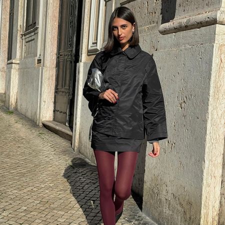 Fashion influencer @salome.mory wearing a chic winter outfit styled with 2024/2025's burgundy tights trend.