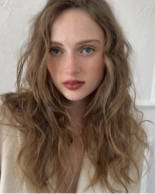 Dewy petal lips on a model with red hair and in a white shirt