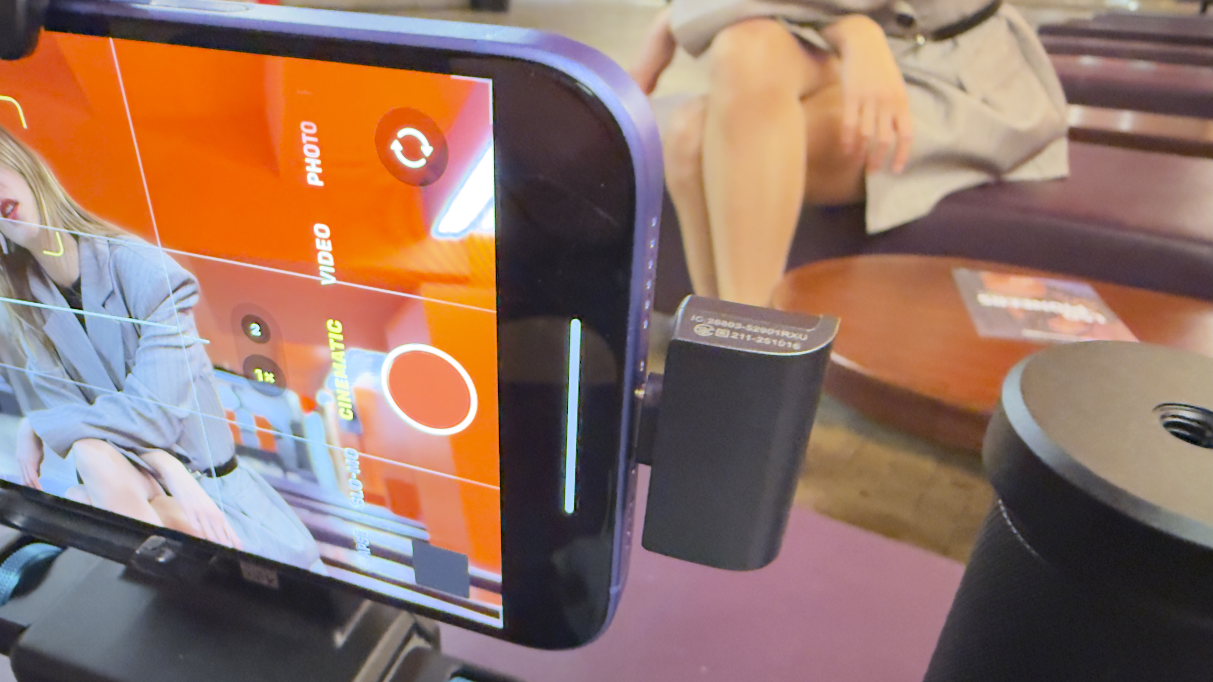 Close-up of a smartphone recording video with a side-mounted wireless microphone receiver attached.