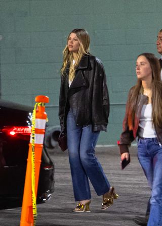 Sofia Richie wears a leather bomber jacket and jeans.