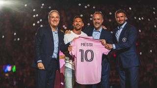 Lionel Messi standing with David Beckham holding an Inter Miami jersey
