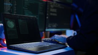 Hooded script kiddie taking laptop out of suitcase, prepared to launch DDoS attack. Close up shot of scammer at computer desk getting notebook from bag, starting work on malware script, camera B