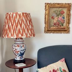 second hand lamp with a graphic shade next to a vintage painting