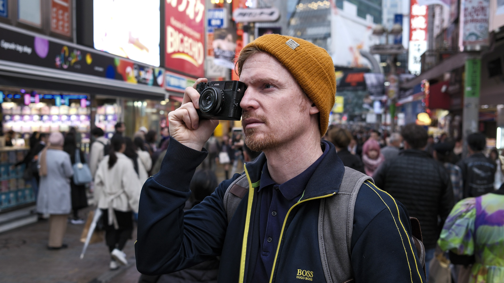 Cámara Fujifilm X100VI sostenida ante el ojo de un fotógrafo en las calles de Tokio