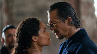 Rosario Dawson and Benjamin Bratt staring at each other in DMZ