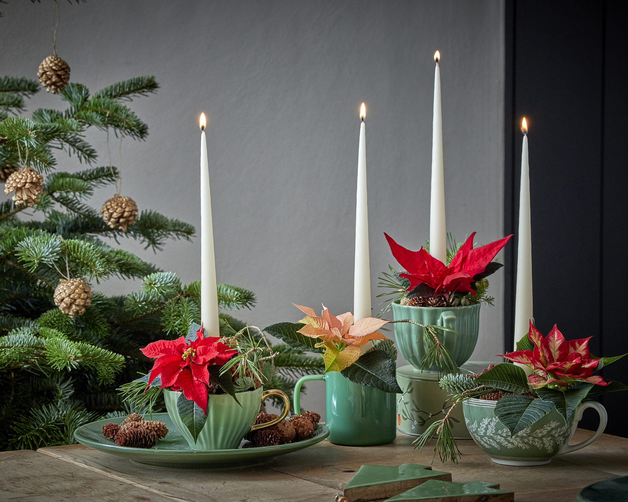 Poinsettia table display with teacups used as vases and candleholders