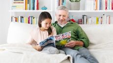 A father and daughter reading The Week Junior