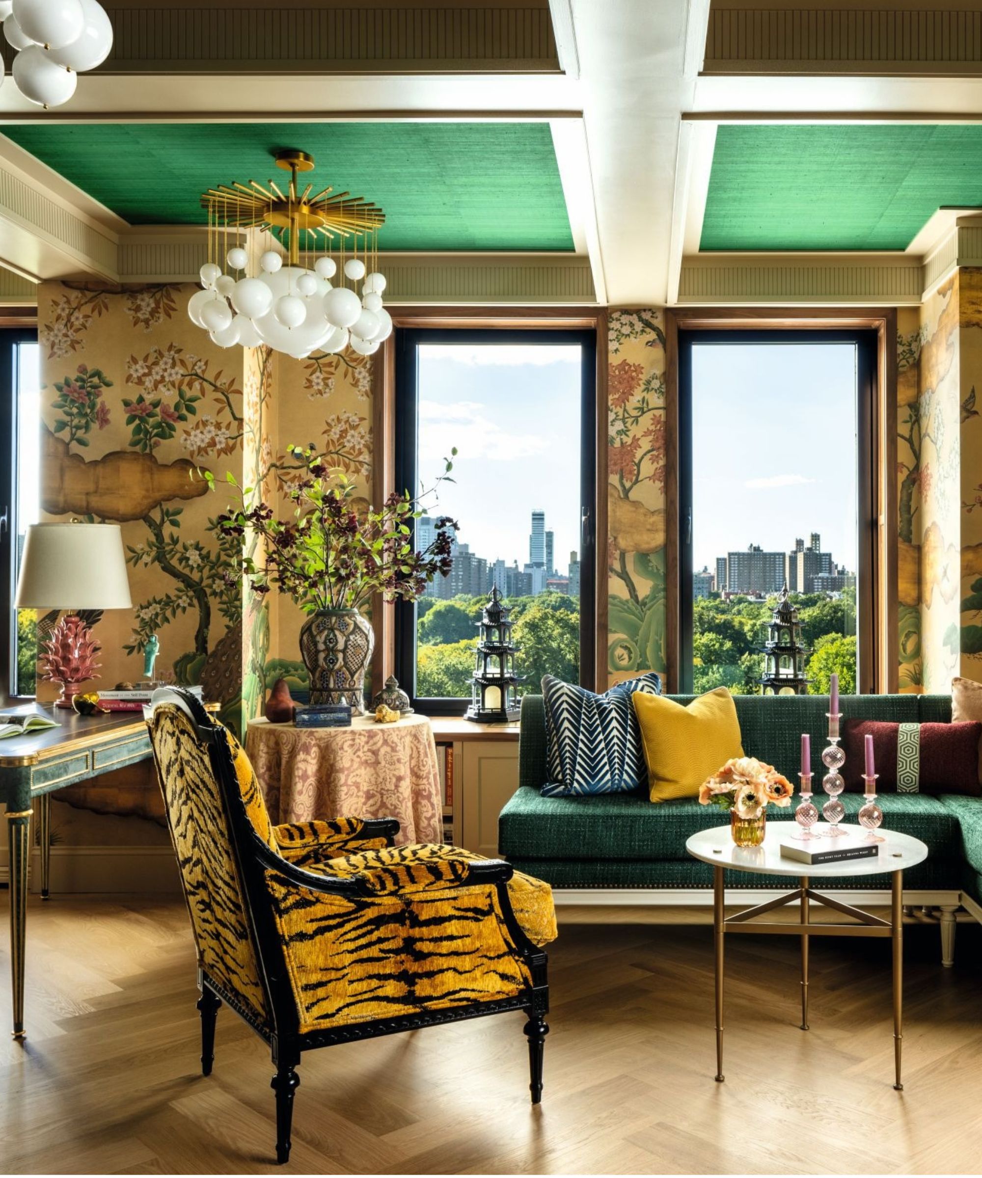 Living room with tiger print chair in front, and green sofa in foreground