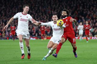 onny Evans and Diogo Dalot of Manchester United battle for possession with Mohamed Salah of Liverpool during the Premier League match between Liverpool FC and Manchester United at Anfield on December 17, 2023 in Liverpool, England. (Photo by Clive Brunskill/Getty Images)