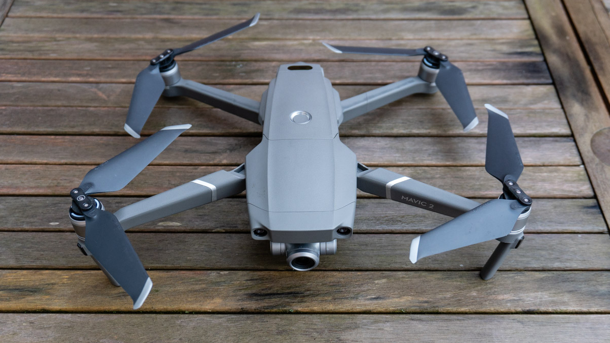 The DJI Mavic 2 Zoom drone on a wooden table preparing for take-off.