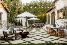  patio and pool area with festoon lighting and fire pit by Kate Anne Designs