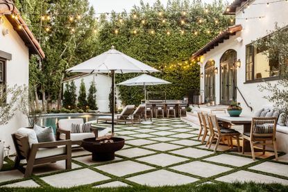 patio and pool area with festoon lighting and fire pit by Kate Anne Designs