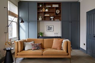 a small living room with built-in storage behind a sofa