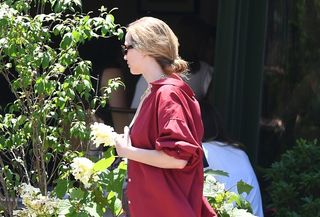 Jennifer Lawrence wearing a red button-down shirt and sunglasses.