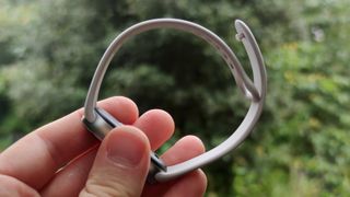 The Xiaomi Smart Band 9 on a man's wrist in front of a green park.