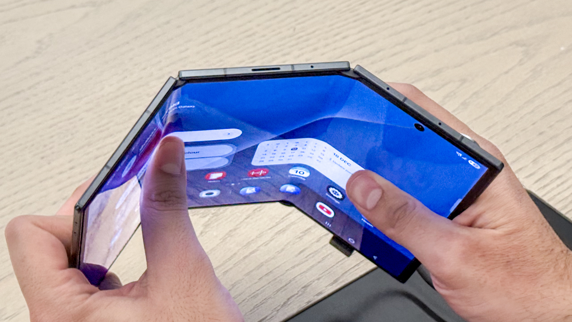 Samsung Galaxy Z TriFold partly open, showing the top edge