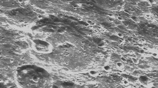 black and white image of the surface of the moon showing craters of all different sizes.