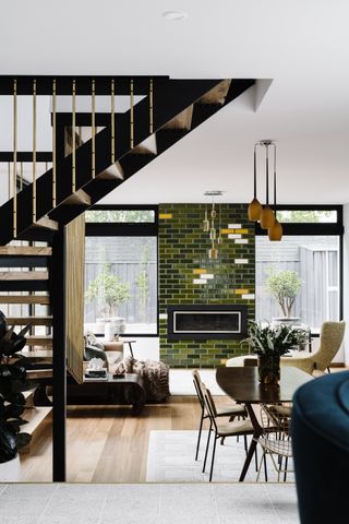 an open plan space with a green tiled fireplace