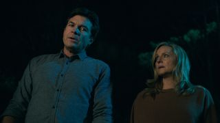 Jason Bateman and Laura Linney stand, looking worried in the woods, in Ozark.