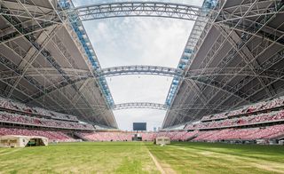 Inside view of sport with open roof and grass field