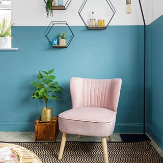 living room with blue and white half painted wall and pink chair