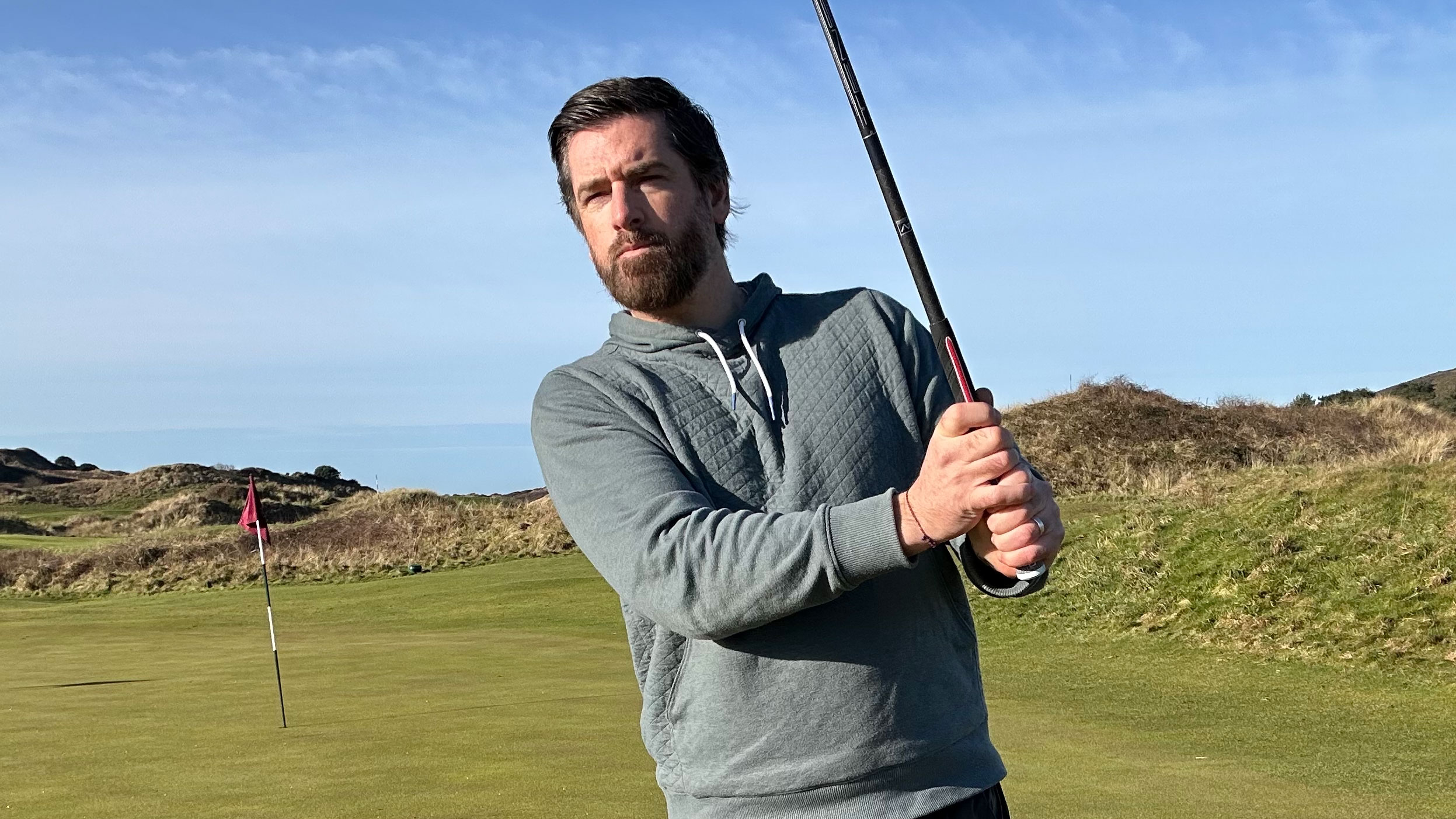 joe ferguson in the follow-through position on the golf course using a ribbed grip