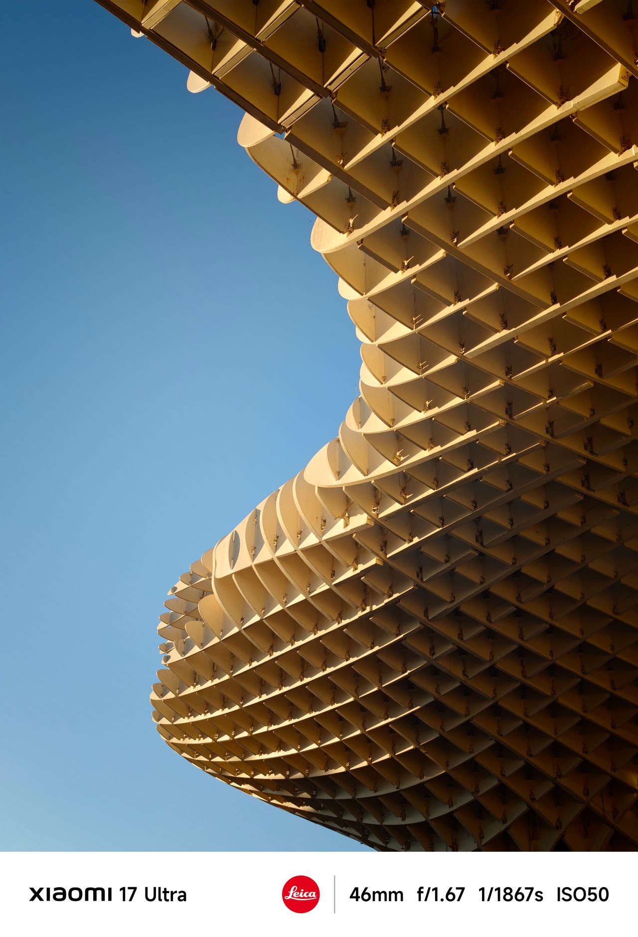 Close-up of the Metropol Parasol&rsquo;s curved wooden lattice structure against a deep blue sky.