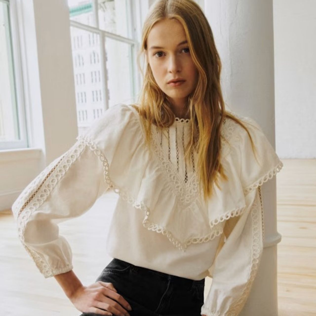 A model wearing a cream shirt from Sezane X Sea NY.