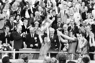 European Cup Final at the Olympic Stadium in Munich. Nottingham Forest 1 v Malmo 0. Nottingham Forest captain John McGovern becomes only the fourth Briton, after Billy McNeill, Bobby Charlton and Emlyn Hughes, to be presented with the European Cup. Behind him, and itching for a touch of the silverware, are Larry Lloyd and Frank Clark, 30th May 1979. (Photo by Monte Fresco/Mirrorpix/Getty Images)