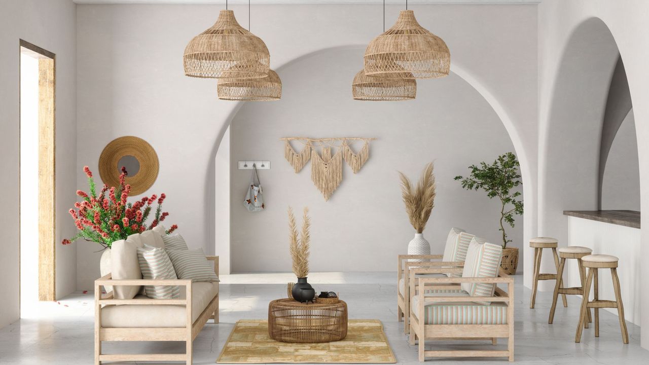 A white walled room furnished in wicker furniture and macrame wall hangings