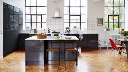 Carlo Viscione: industrial-style kitchen with dark blue units, parquet flooring and grid-pattern white splashback tiles