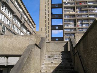 The concrete steps leading up to the Trellick Tower with a blue sky in the backdrop