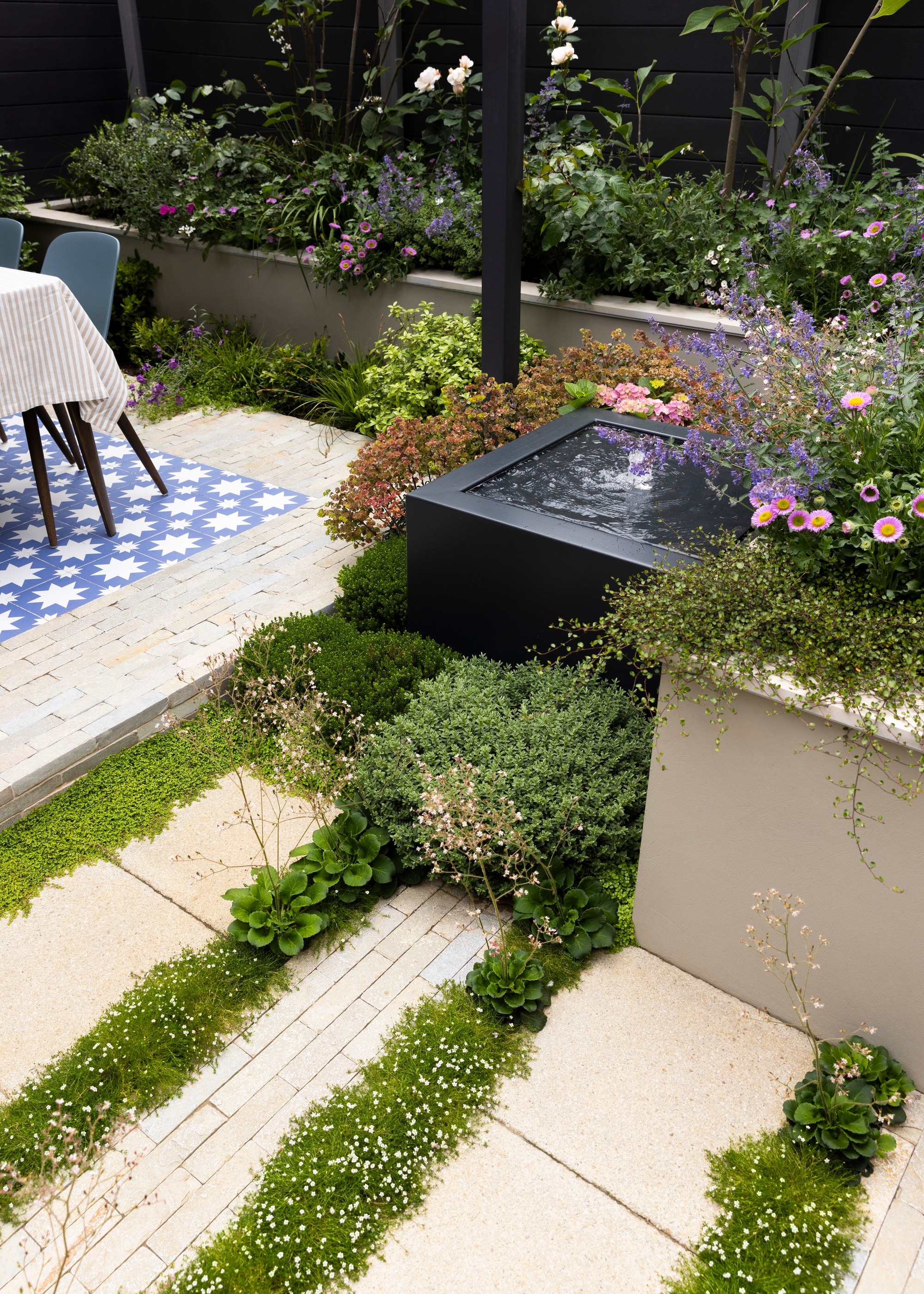garden with plantings between paving for subtle drainage solutions