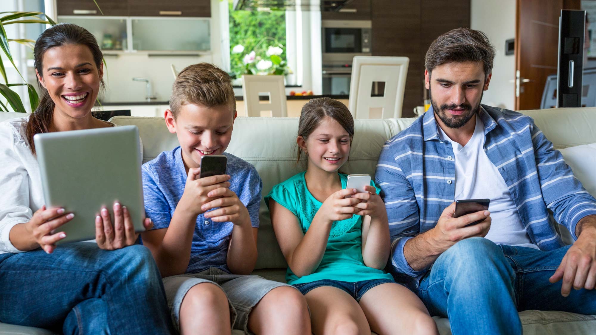 Una familia feliz usando dispositivos conectados a Internet