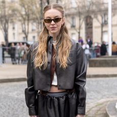 Sydney Sweeney wearing a half-up half down hairstyle and sunglasses. 