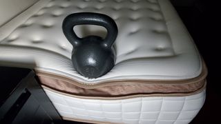 A 50lb weight at the foot of a Cloverlane Hybrid Mattress to test its edge support