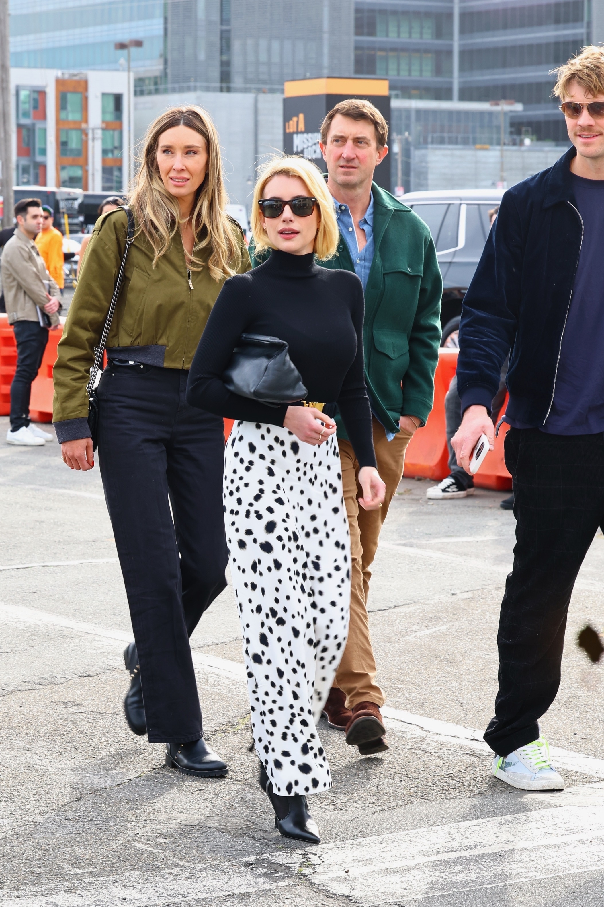 Emma Roberts wearing a black turtleneck, polka dot skirt, and black boots
