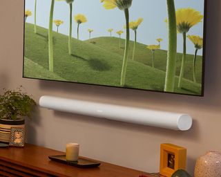 Sonos Arc in white mounted to wall underneath TV