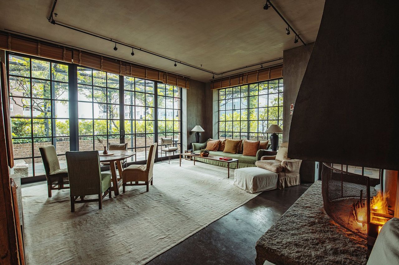 A modernism-inspired hotel features huge spaces letting plenty of natural light in, wooden and leather furnishings, wall art, and an earthy palette throughout its building.