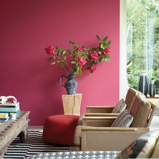 Red living room wall with flowers in vase