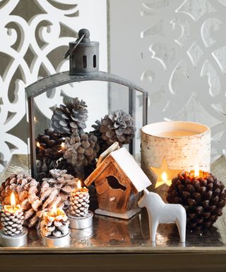 Handful of pinecone candles on a mantelpiece